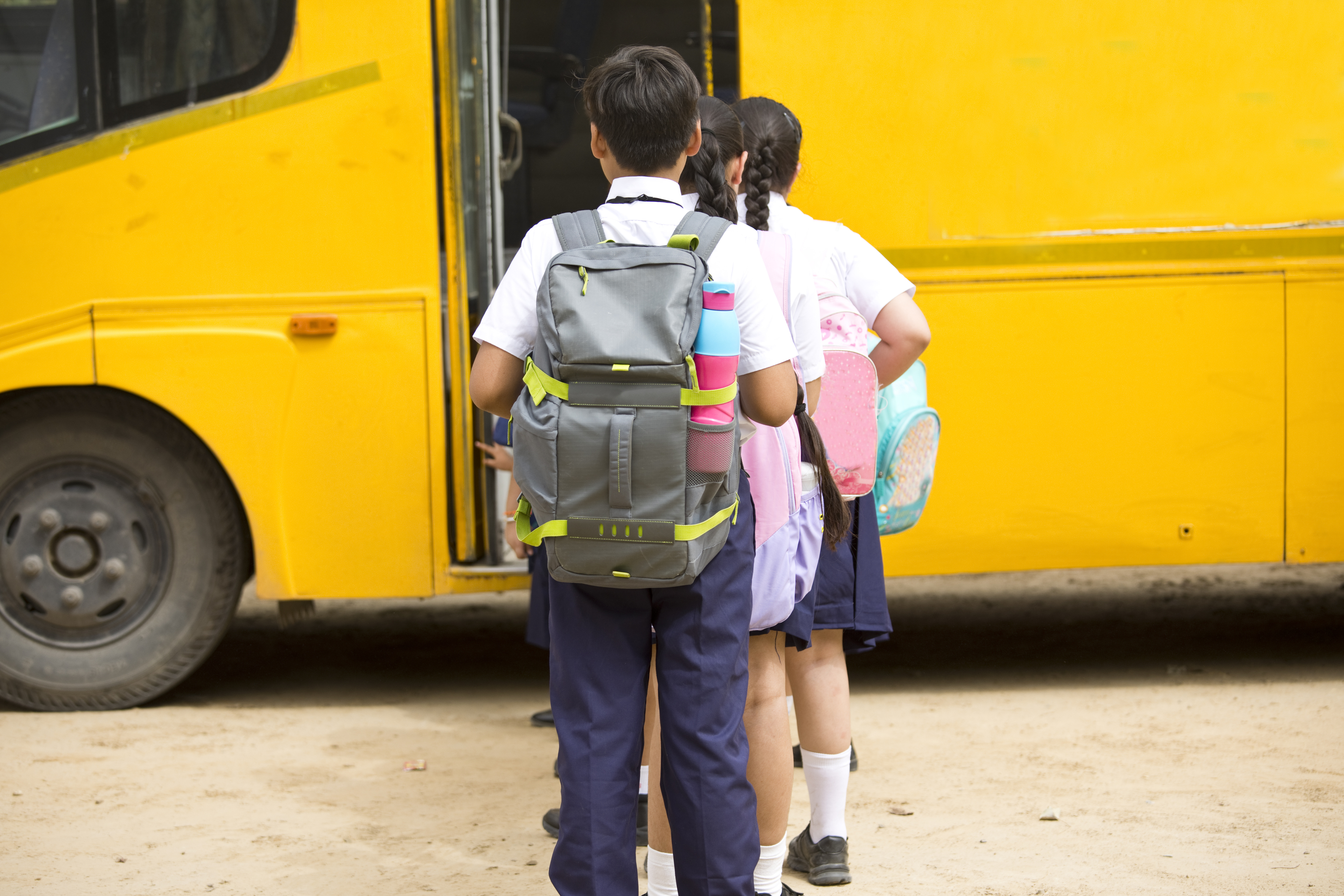 Group of school children boarding the school bus outdoor
